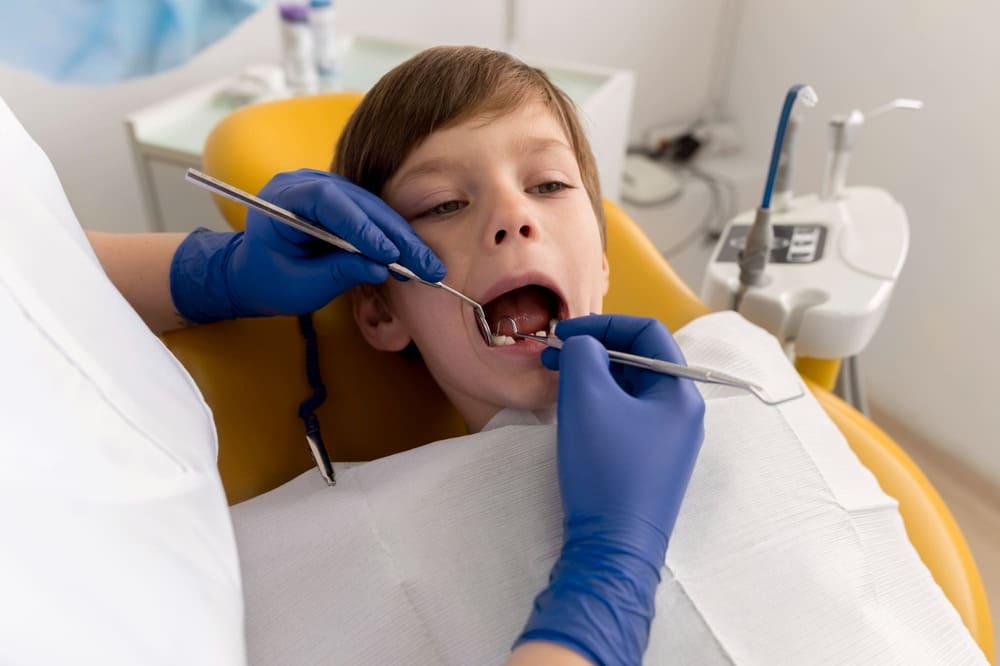 Kids dental fillings Scarborough: dentist examining a child's teeth before a filling at AF Dental
